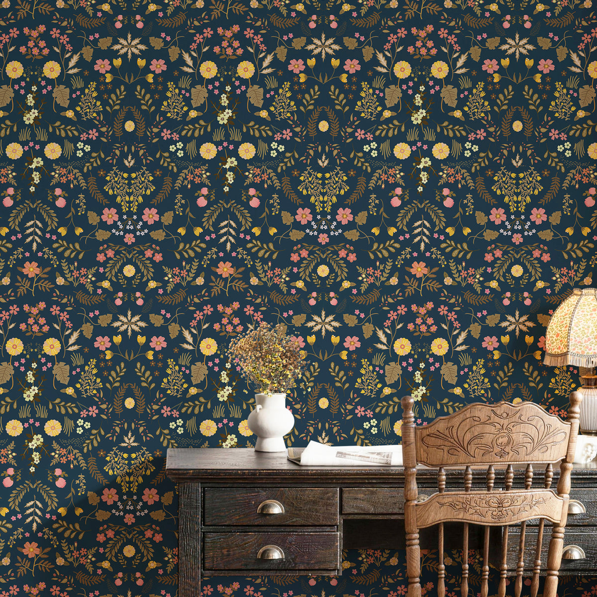 Dark‑blue wildflower peel and stick wallpaper serves as a stunning accent wall behind the vintage wooden desk, creating a cozy, artistic working corner.