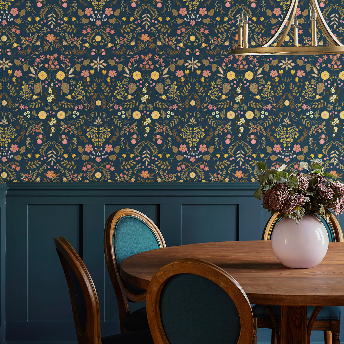 Botanical small‑flower wallpaper installed on the upper dining‑room wall, matched with navy wainscoting, wooden dining table and upholstered chairs for sophisticated dining decor.