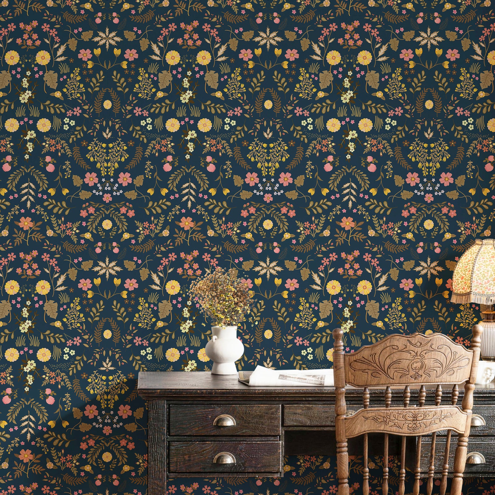 Dark‑blue wildflower peel and stick wallpaper serves as a stunning accent wall behind the vintage wooden desk, creating a cozy, artistic working corner.